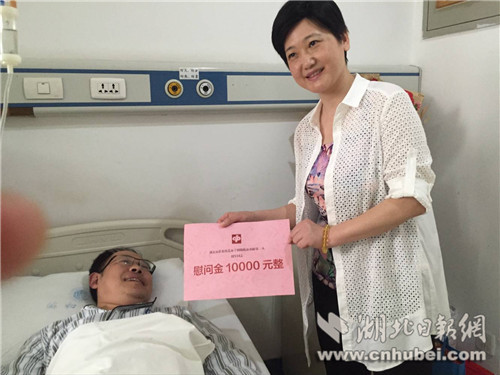 湖北福彩副主任陈红向周军转交福彩1万元慰问金.王小飞 摄