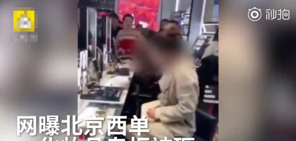 女子在北京西单砸化妆品专柜,被保安摁倒,涉嫌
