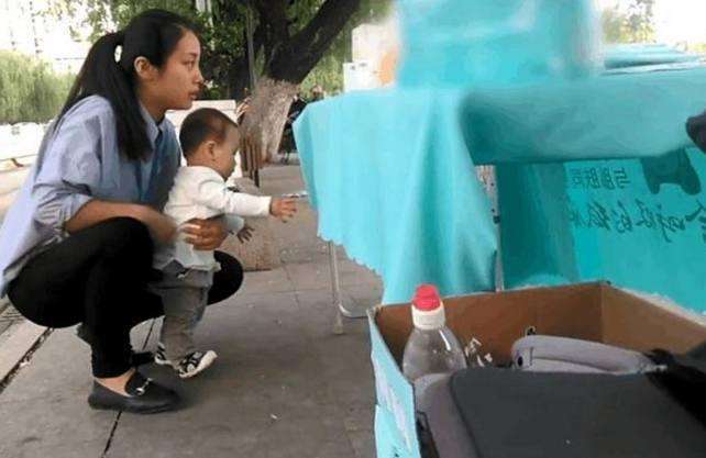 90后妈妈抱着一岁儿子摆地摊,宝妈真厉害,也可