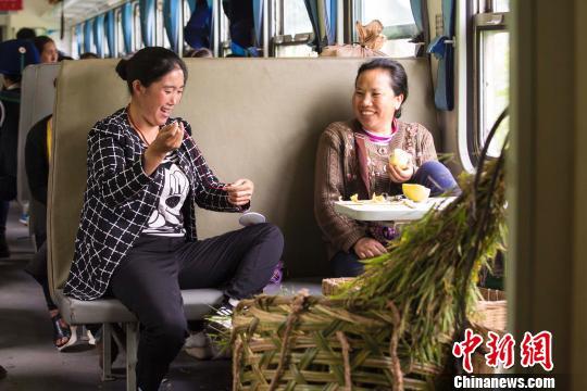 两名彝族旅客正在闲话家常 龚萱 摄