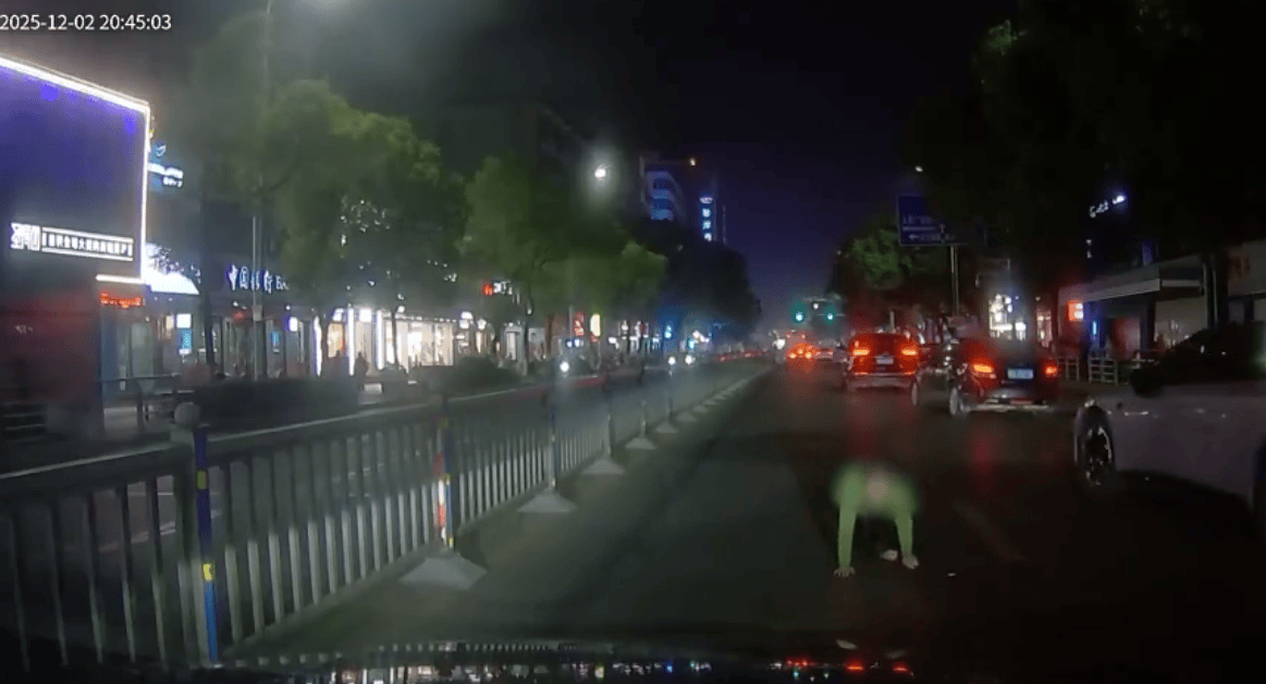 女子在夜晚车流中趴地上要钱